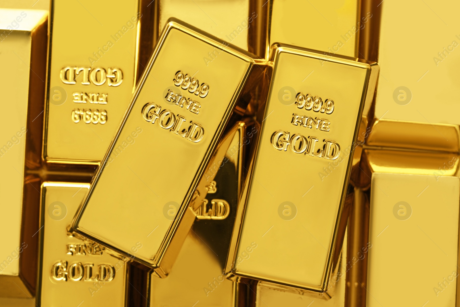 Photo of Many shiny gold bars as background, top view