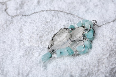 Photo of Beautiful silver necklace with pure quartz gemstones on snow
