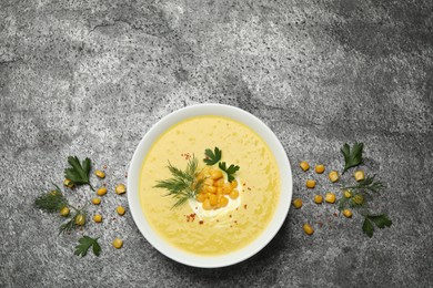 Photo of Delicious creamy corn soup served on grey table, flat lay