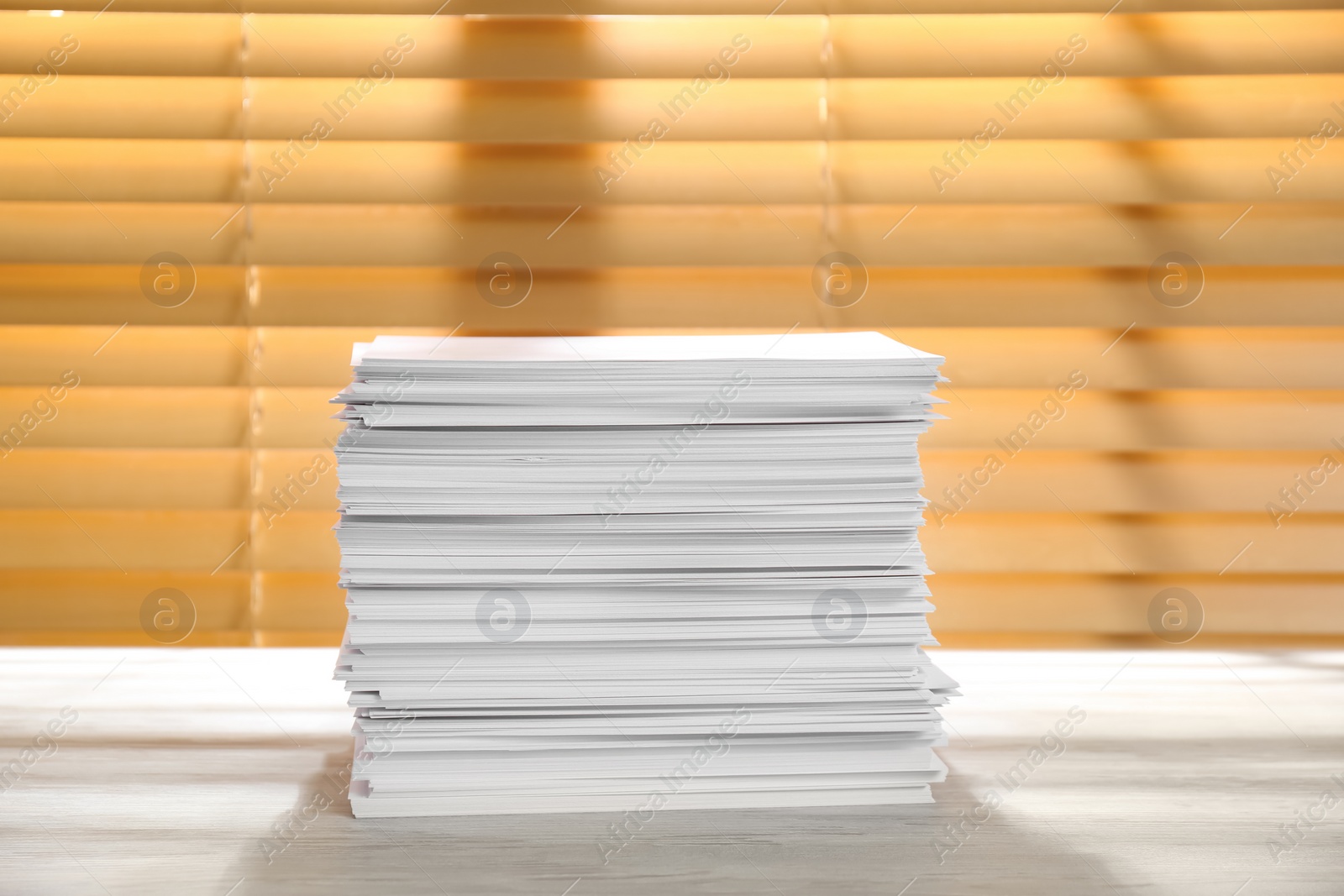 Photo of Stack of paper sheets on white wooden table