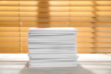 Photo of Stack of paper sheets on white wooden table