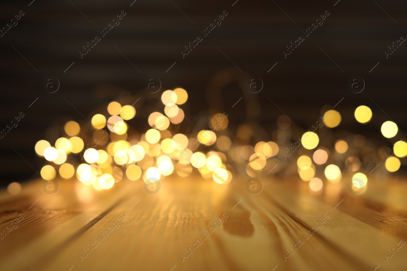 Photo of Empty wooden surface and blurred lights on background. Bokeh effect