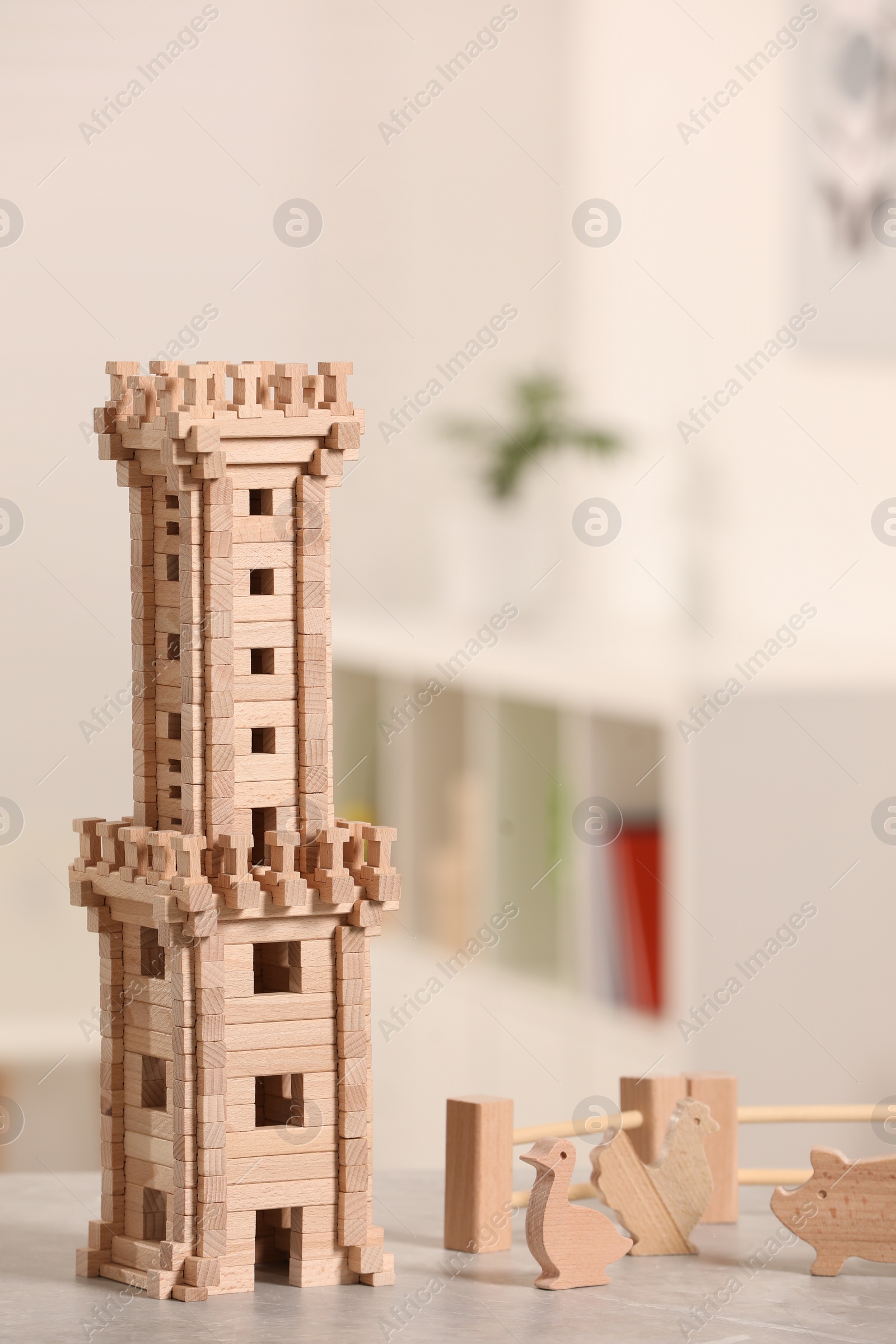 Photo of Wooden tower, animals and fence on table indoors, space for text. Children's toys