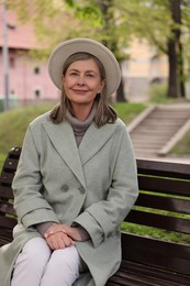 Photo of Beautiful senior woman sitting on bench in park