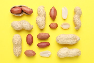 Fresh peanuts on yellow background, flat lay