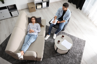 Professional psychotherapist working with patient in office, above view