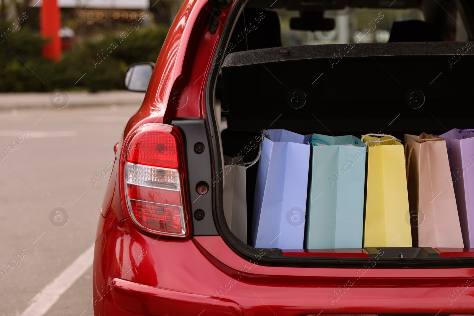 Photo of Shopping bags in car trunk outdoors, closeup