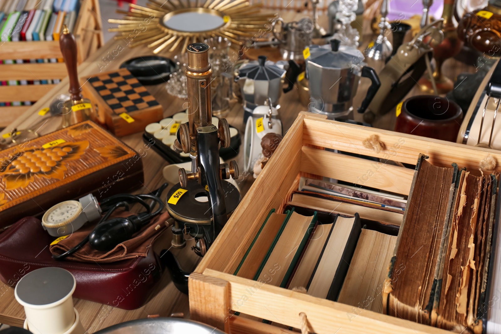 Photo of Many different items on wooden table. Garage sale