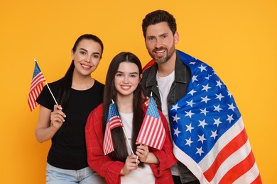 4th of July - Independence Day of USA. Happy family with American flags on yellow background
