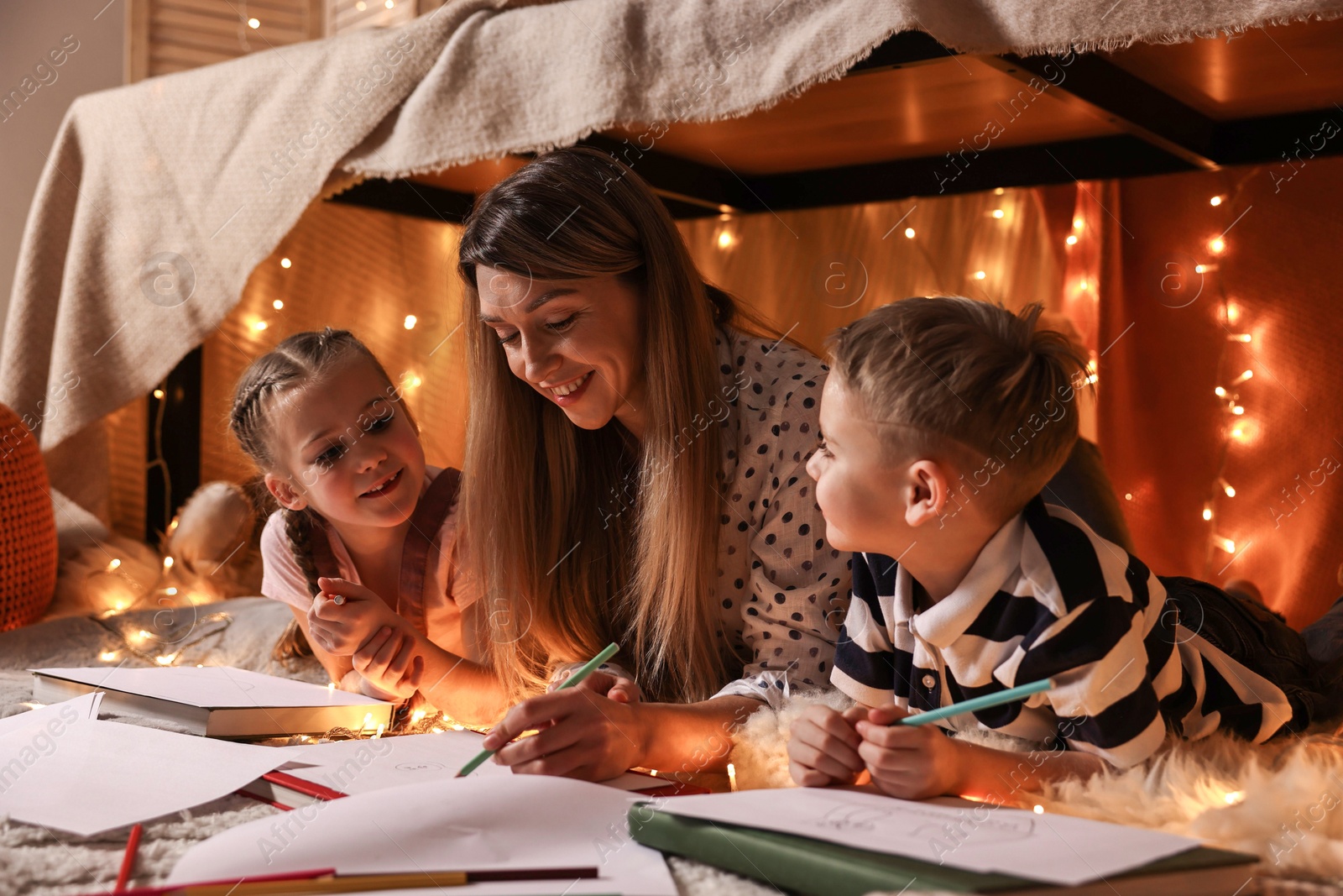 Photo of Mother and her children drawing in play tent at home