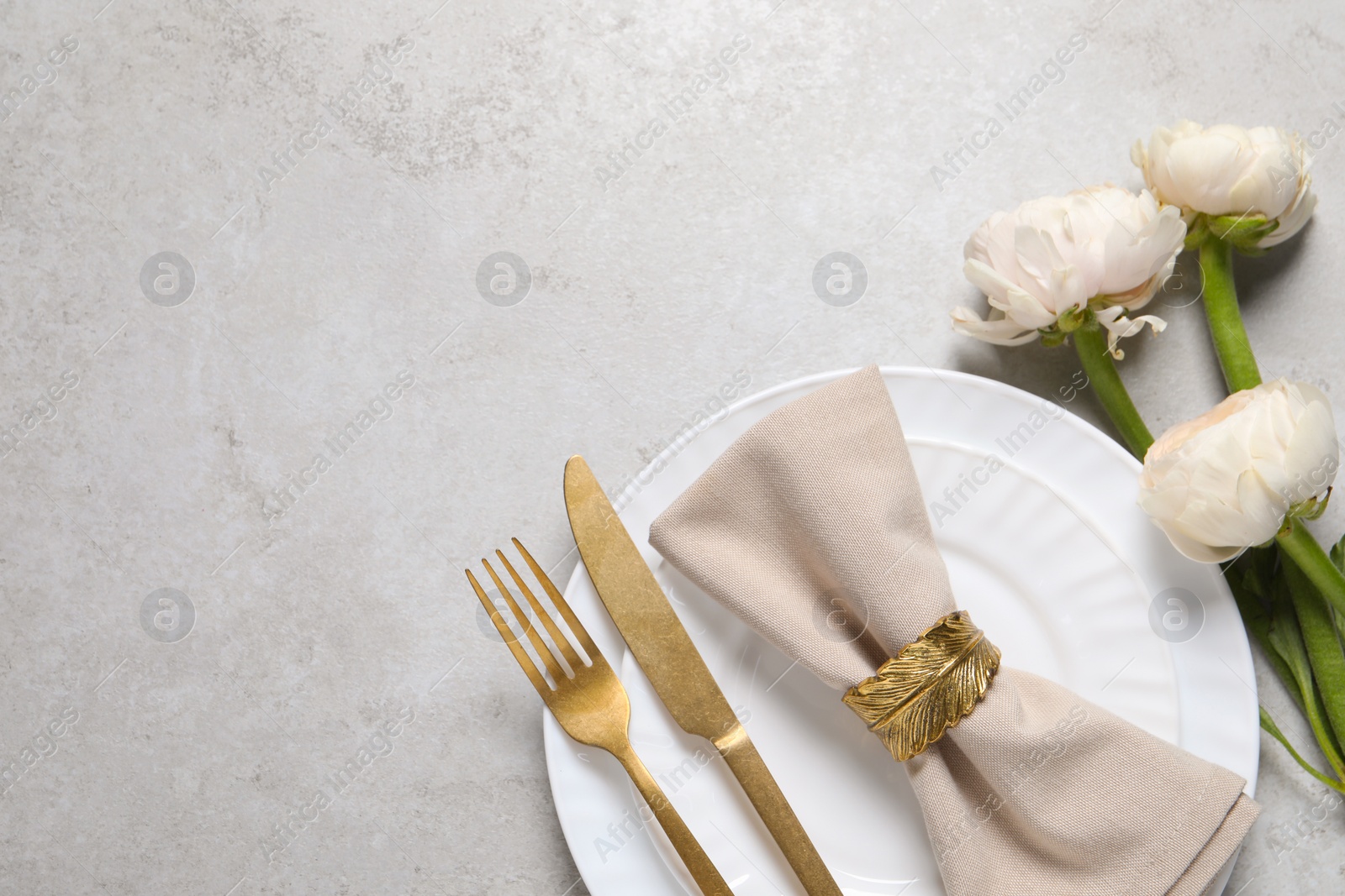 Photo of Stylish table setting with cutlery and flowers on grey background, flat lay. Space for text