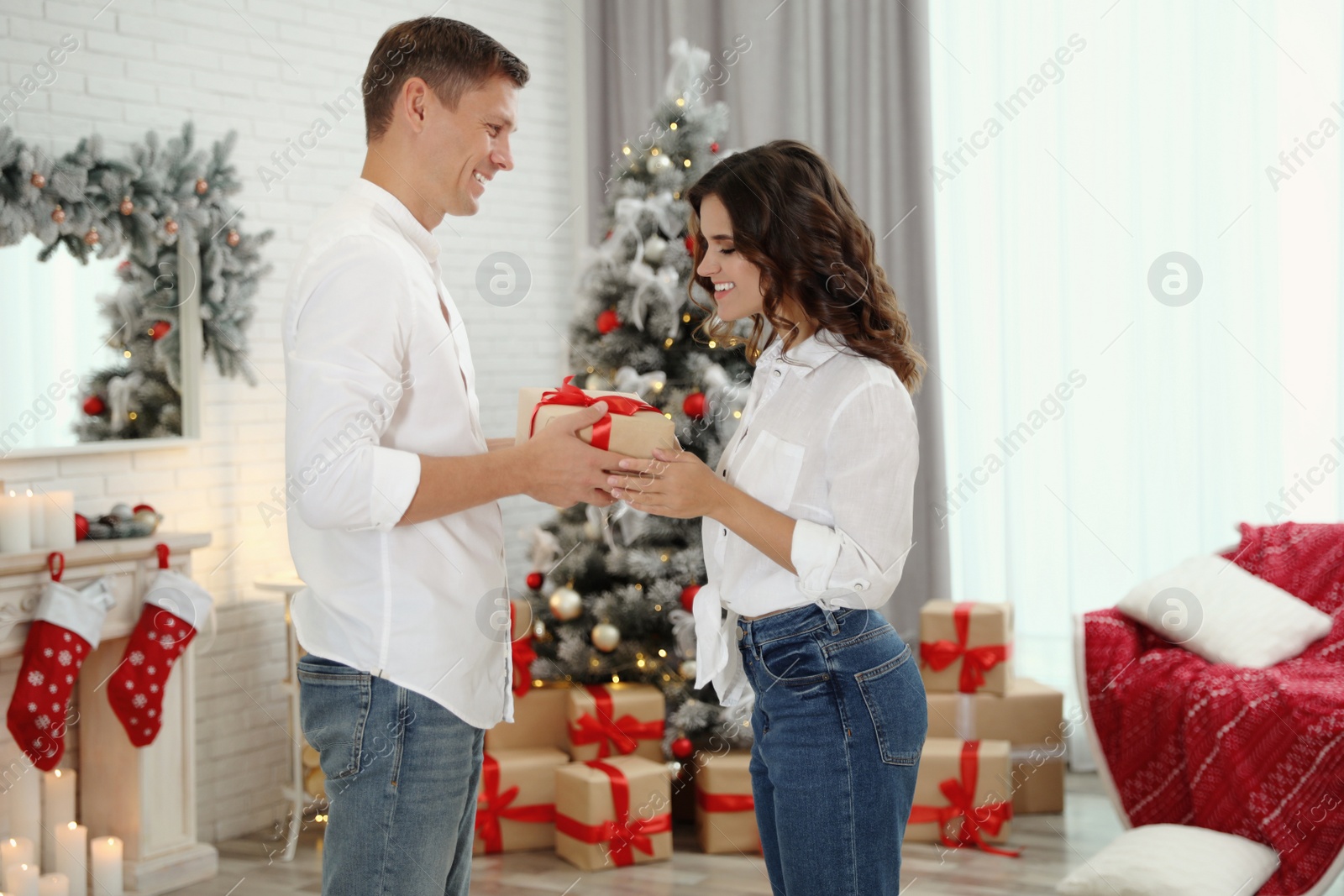 Image of Happy couple with Christmas gift at home