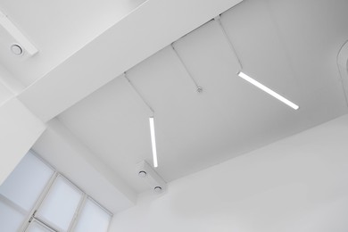 Ceiling with modern lights in room, low angle view