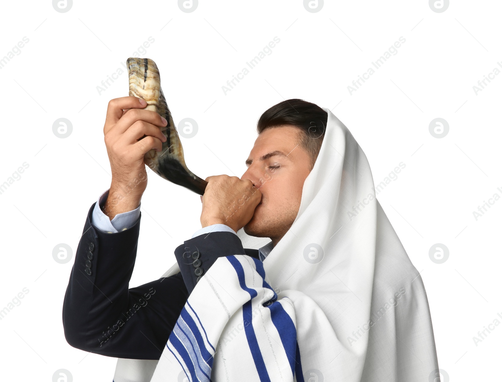 Photo of Jewish man in tallit blowing shofar on white background. Rosh Hashanah celebration