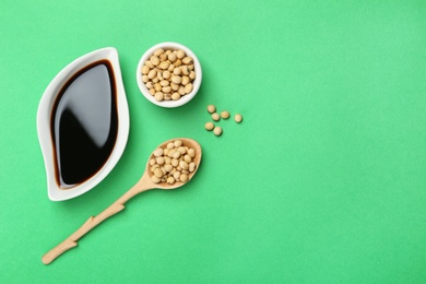 Flat lay composition with soy sauce and beans on color background. Space for text