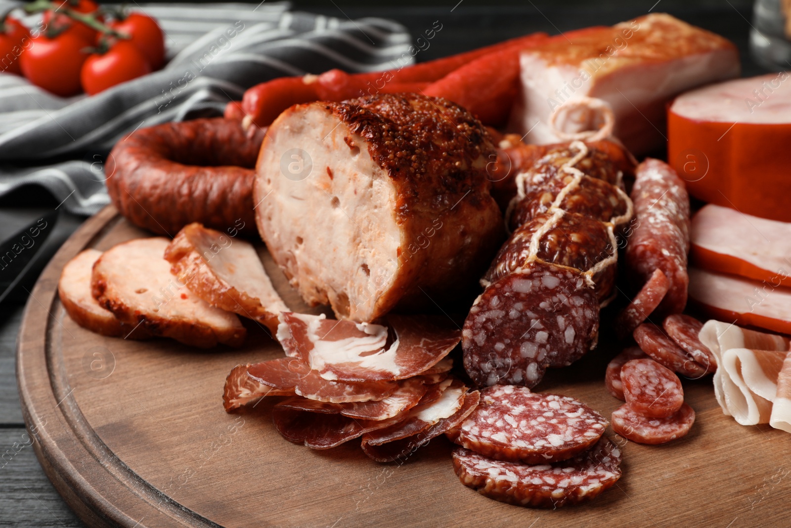 Photo of Cutting board with different sliced meat products served on table