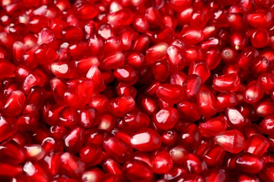 Many tasty pomegranate seeds as background, closeup