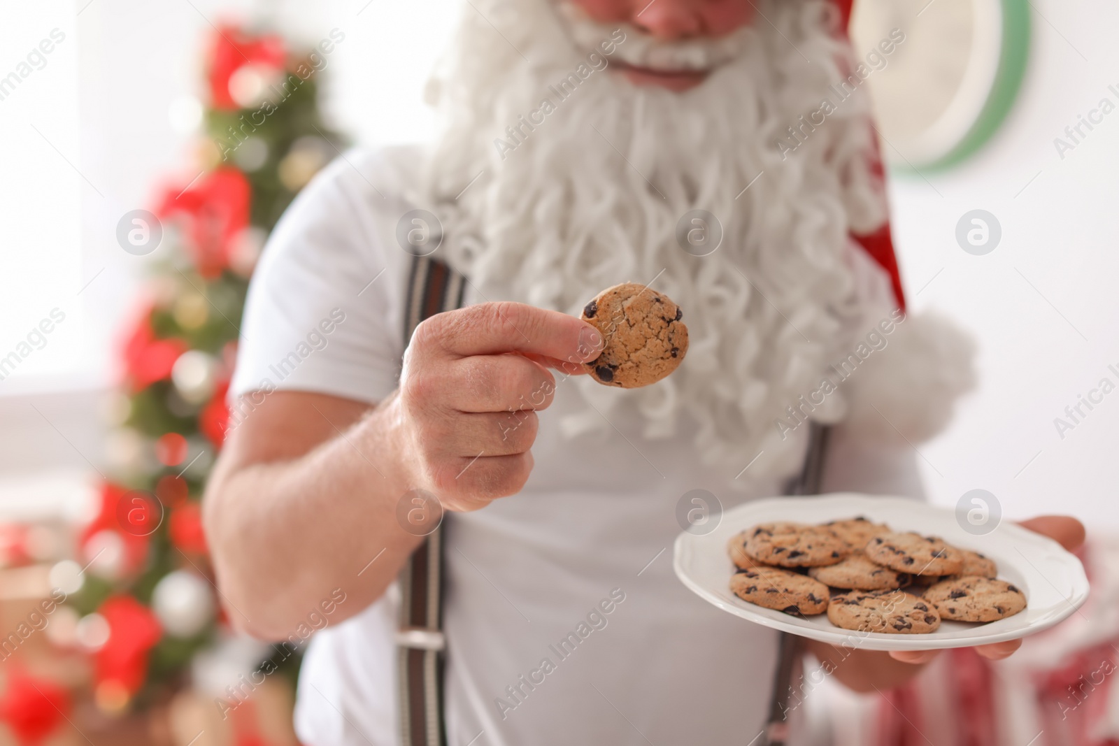 Photo of Authentic Santa Claus with plate of cookies indoors