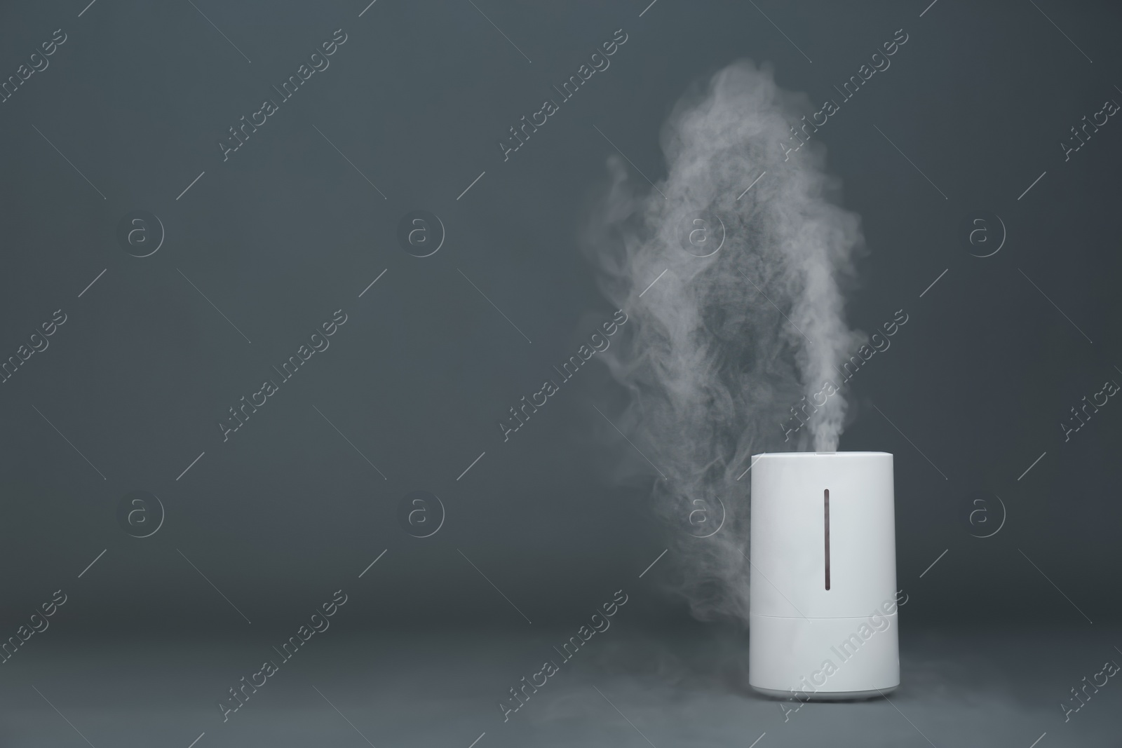 Photo of Modern air humidifier on grey background. Space for text