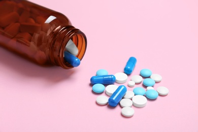 Photo of Bottle with pills on color background