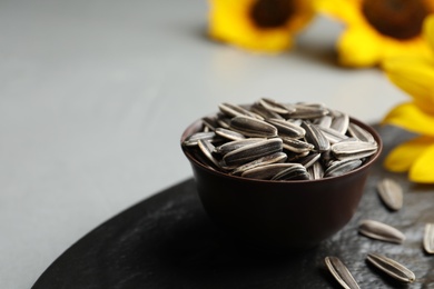 Raw sunflower seeds on grey table, closeup. Space for text