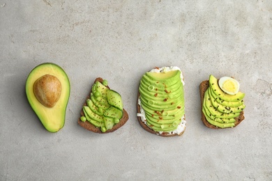 Tasty crisp rye toasts with avocado on table, flat lay