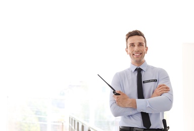 Photo of Male security guard with portable radio transmitter indoors