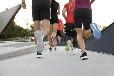 Group of people running outdoors, closeup view