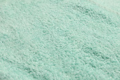 Photo of Soft light turquoise towel as background, closeup