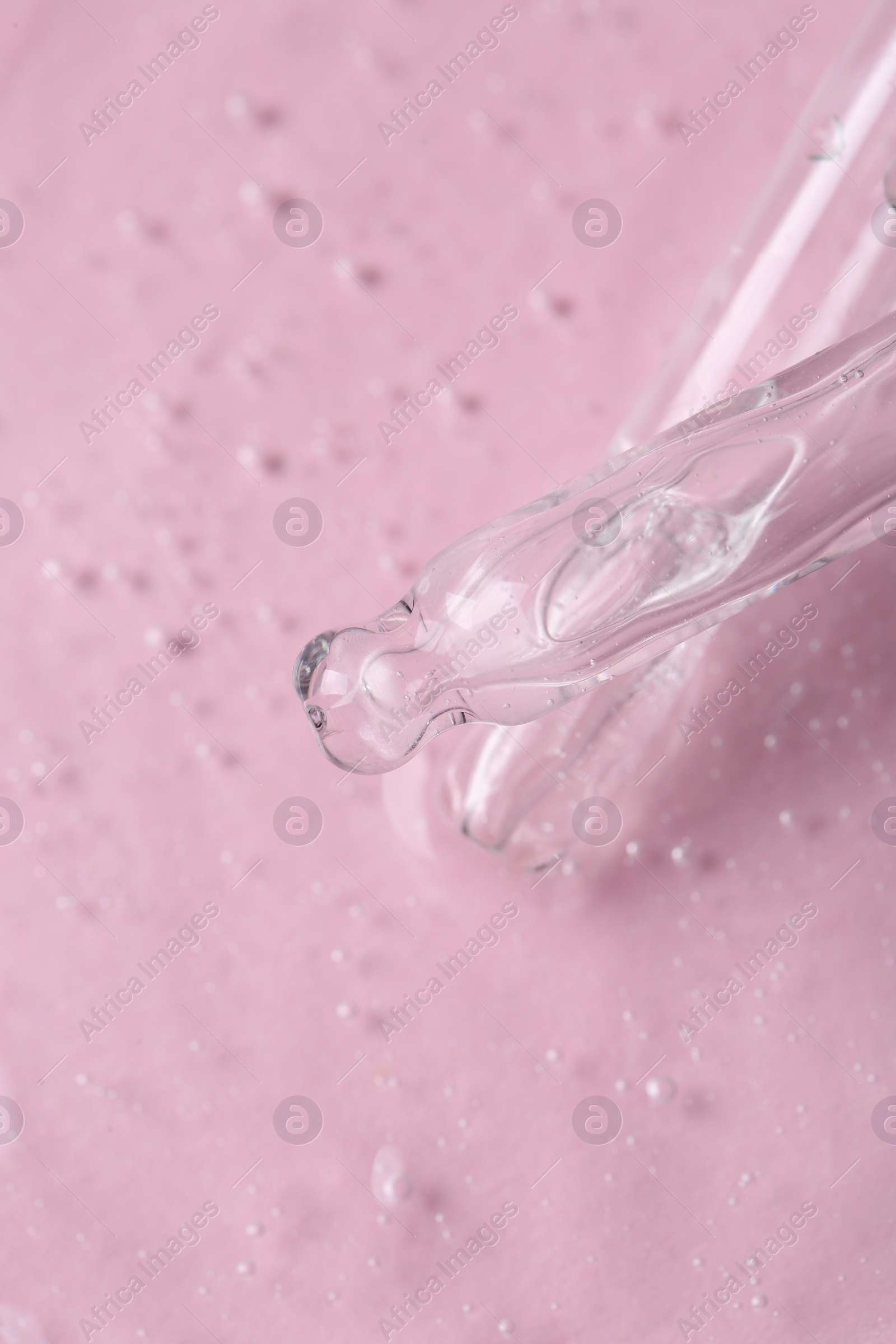 Photo of Pipettes with cosmetic serum on pink background, closeup