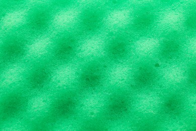 Photo of Green cleaning sponge as background, top view