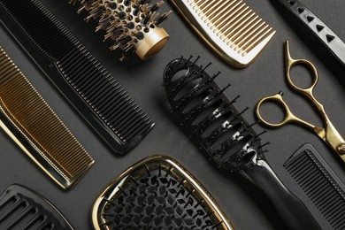Photo of Hairdressing tools on dark background, flat lay