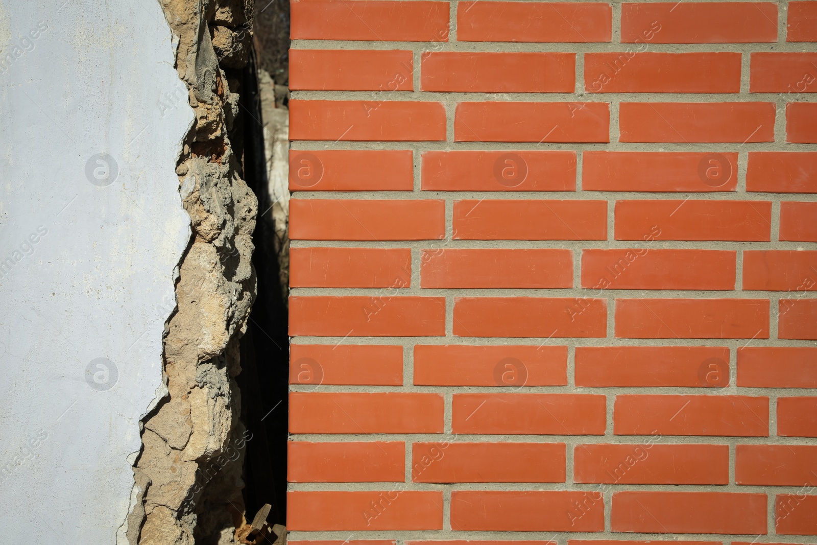 Photo of Old white building near new brick wall. Earthquake aftermath