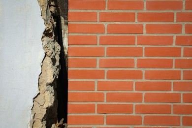 Photo of Old white building near new brick wall. Earthquake aftermath