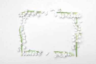 Photo of Frame made with lily of the valley flowers on light grey background, flat lay. Space for text