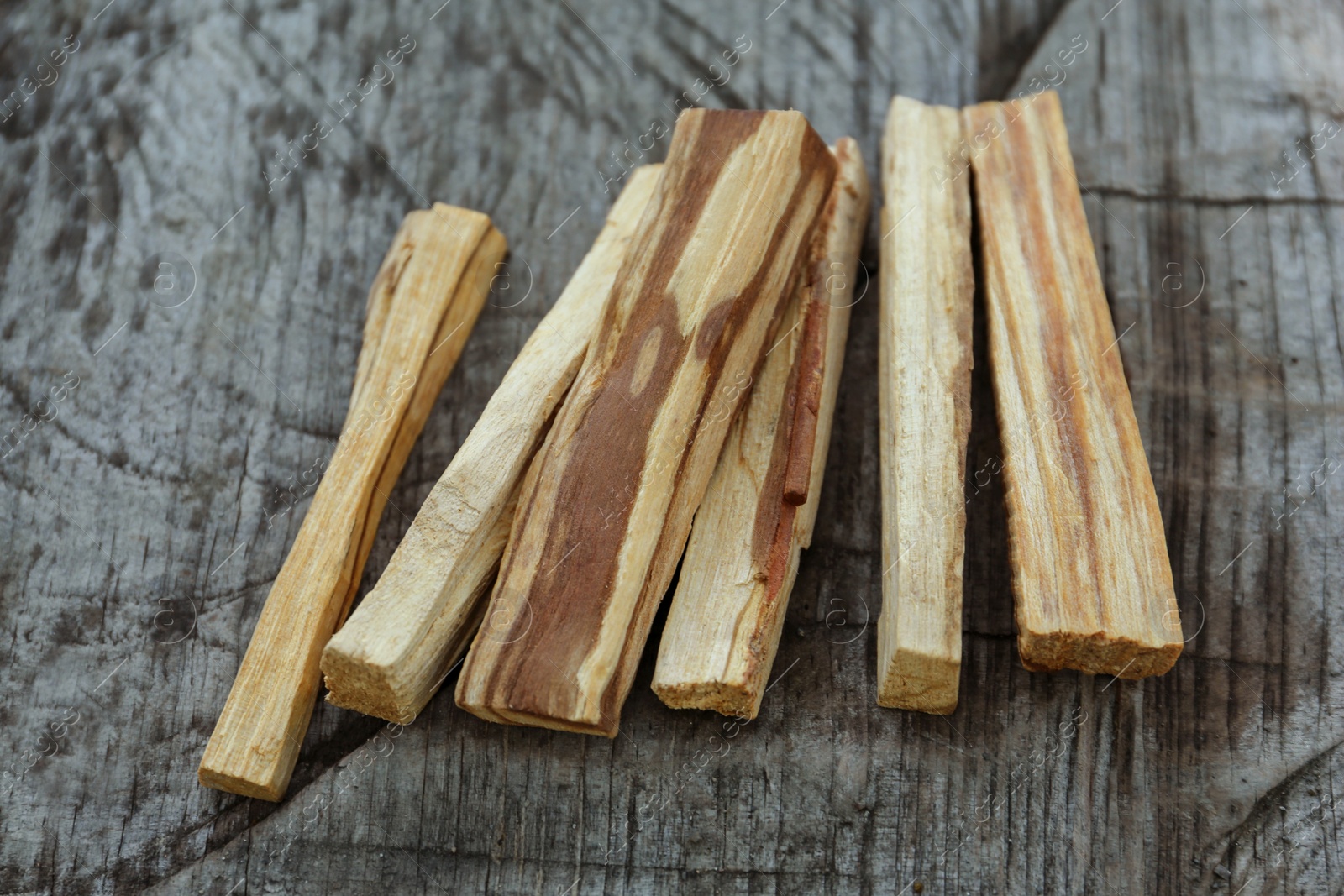 Photo of Palo santo sticks on wooden table, closeup