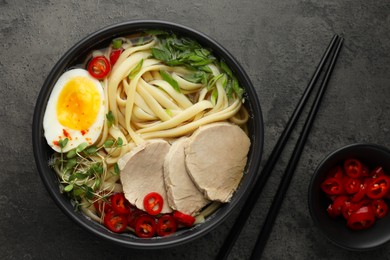 Photo of Delicious ramen with meat in bowl served on wooden table, flat lay. Noodle soup