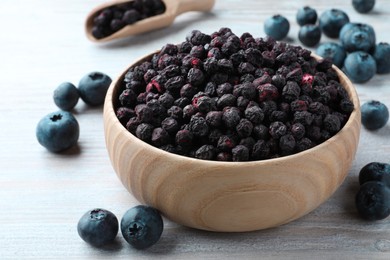 Freeze dried and fresh blueberries on white wooden table, closeup