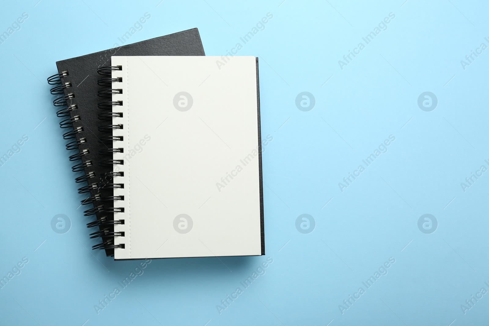 Photo of Notebooks on black background, top view. Space for text