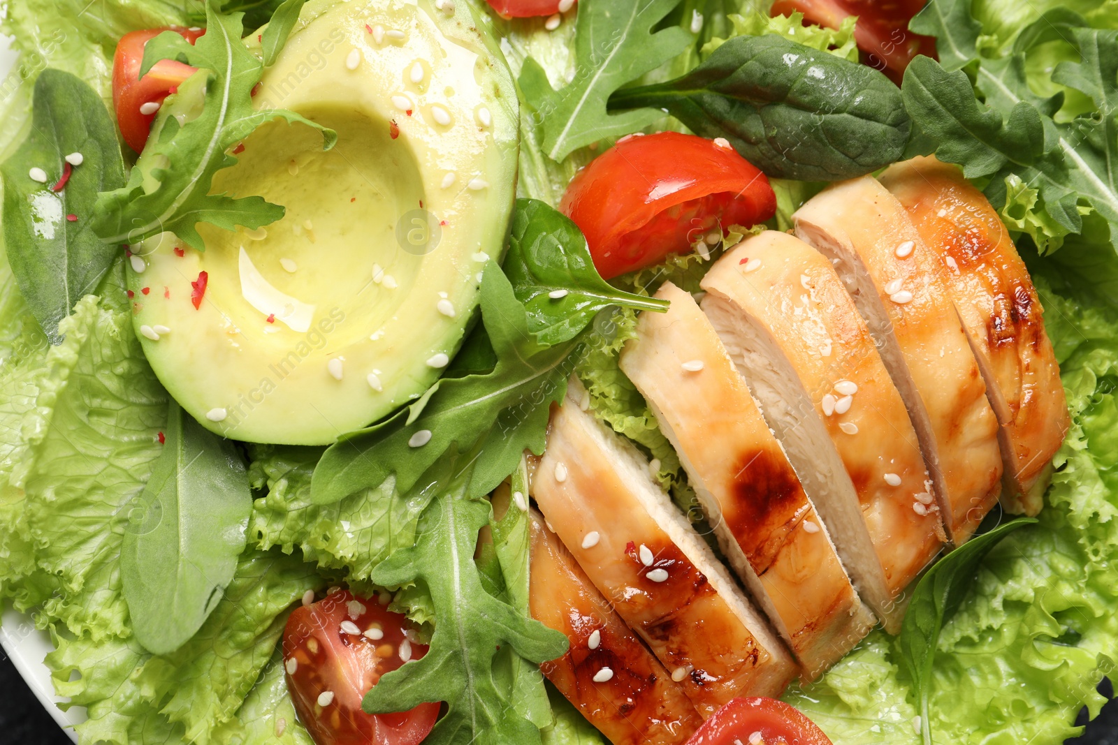 Photo of Delicious salad with chicken, cherry tomato and avocado, top view