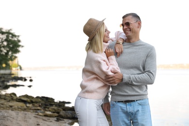 Happy couple in stylish sweaters on beach
