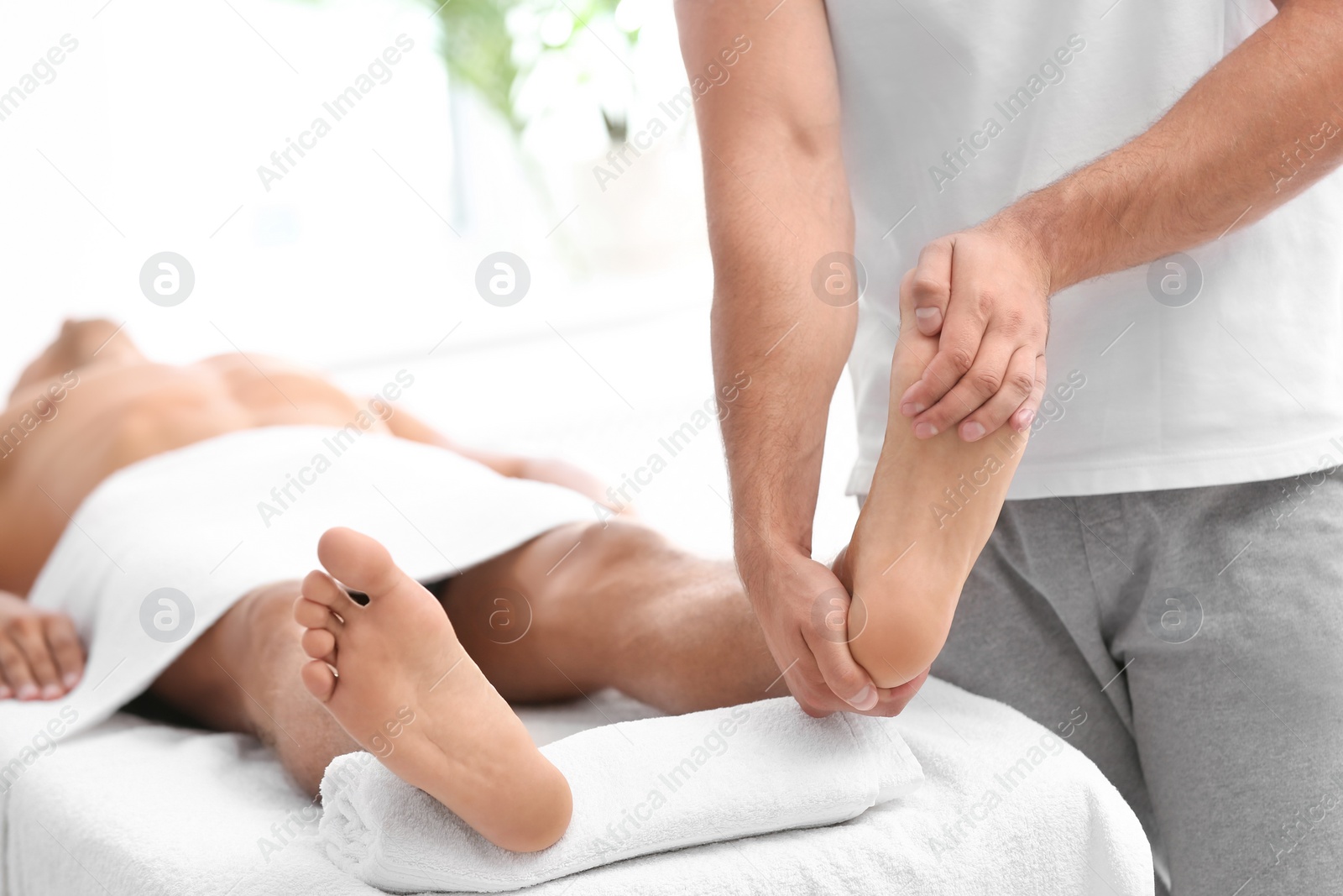 Photo of Young woman receiving massage in salon, closeup