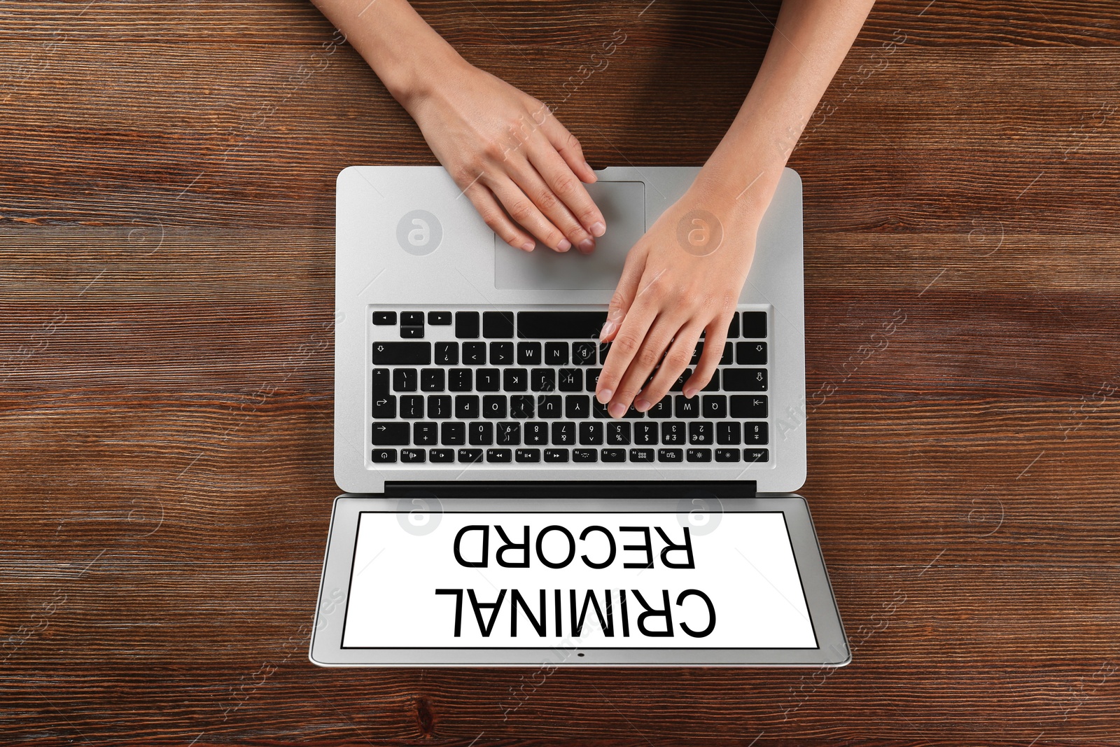 Image of Woman using laptop with words CRIMINAL RECORD at table, top view