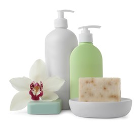 Soap bars, bottle dispensers and lily on white background