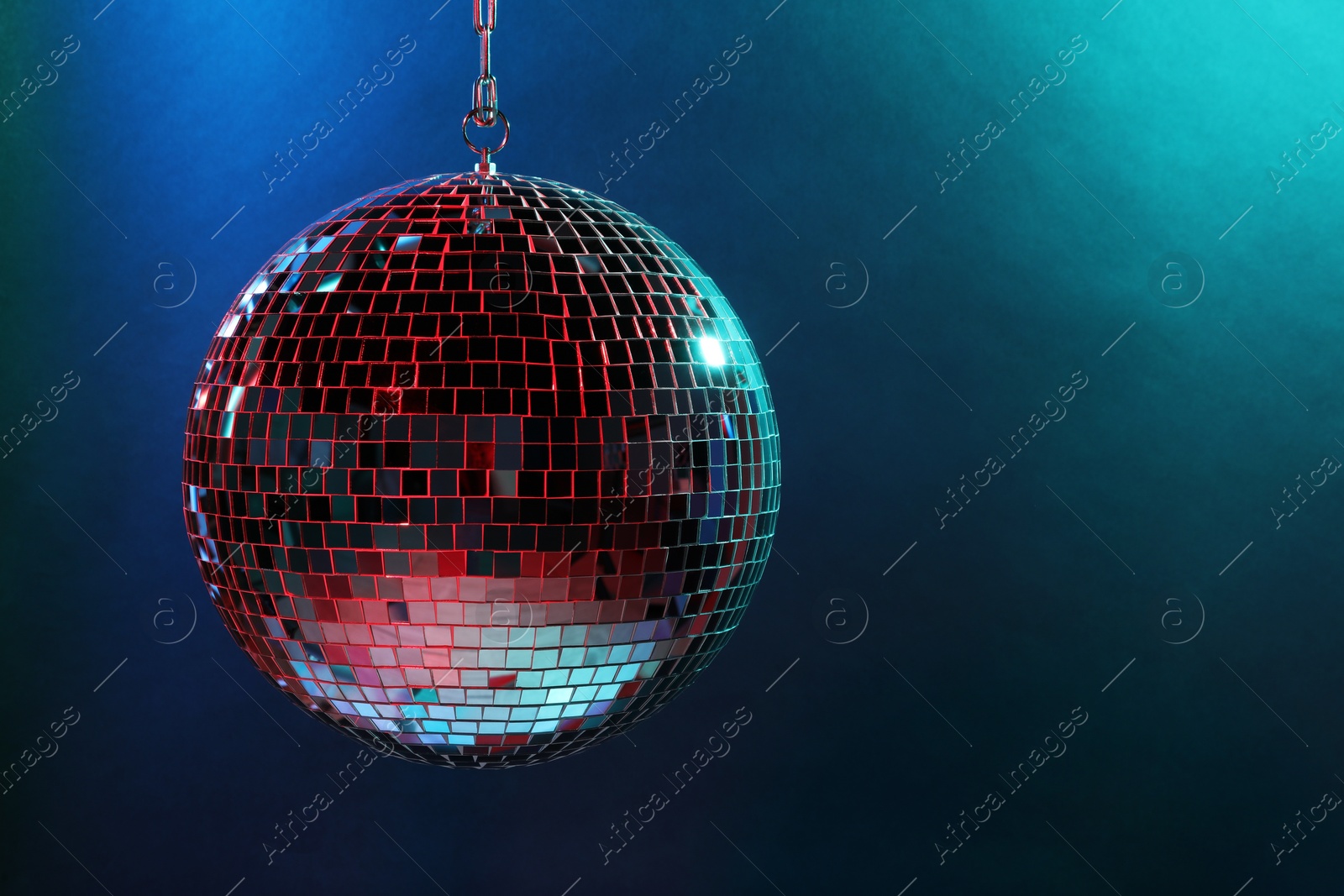 Photo of Shiny disco ball under blue lights, space for text