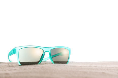Photo of Stylish sunglasses on sand against white background. Space for text