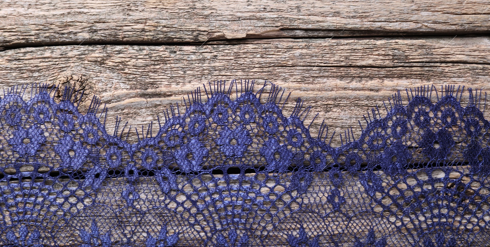 Photo of Beautiful lace on wooden table, top view