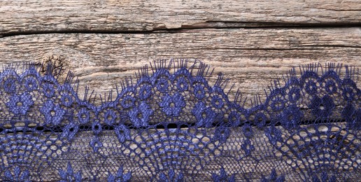 Photo of Beautiful lace on wooden table, top view