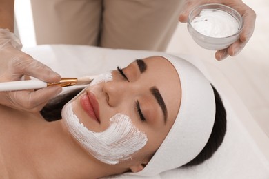 Young woman during face peeling procedure in salon