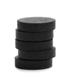 Photo of Stack of black pills on white background. Medical treatment